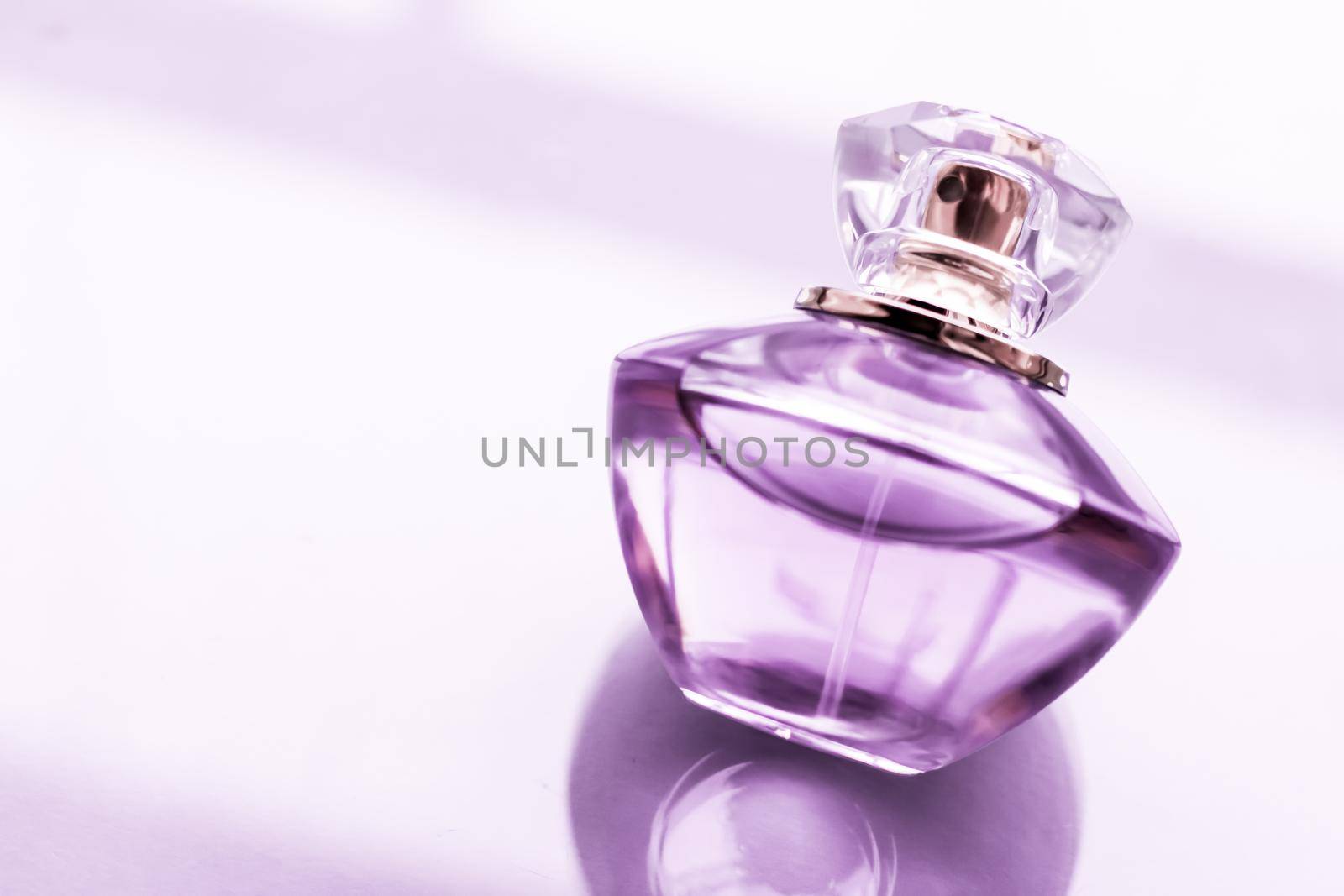 Perfumery, spa and branding concept - Purple perfume bottle on glossy background, sweet floral scent, glamour fragrance and eau de parfum as holiday gift and luxury beauty cosmetics brand design