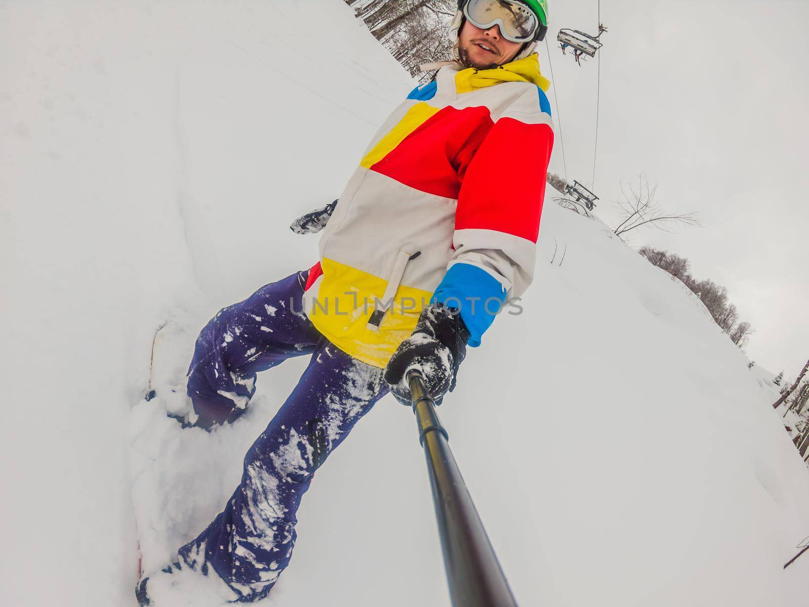 Skier skiing downhill during cloudy day in high mountains.