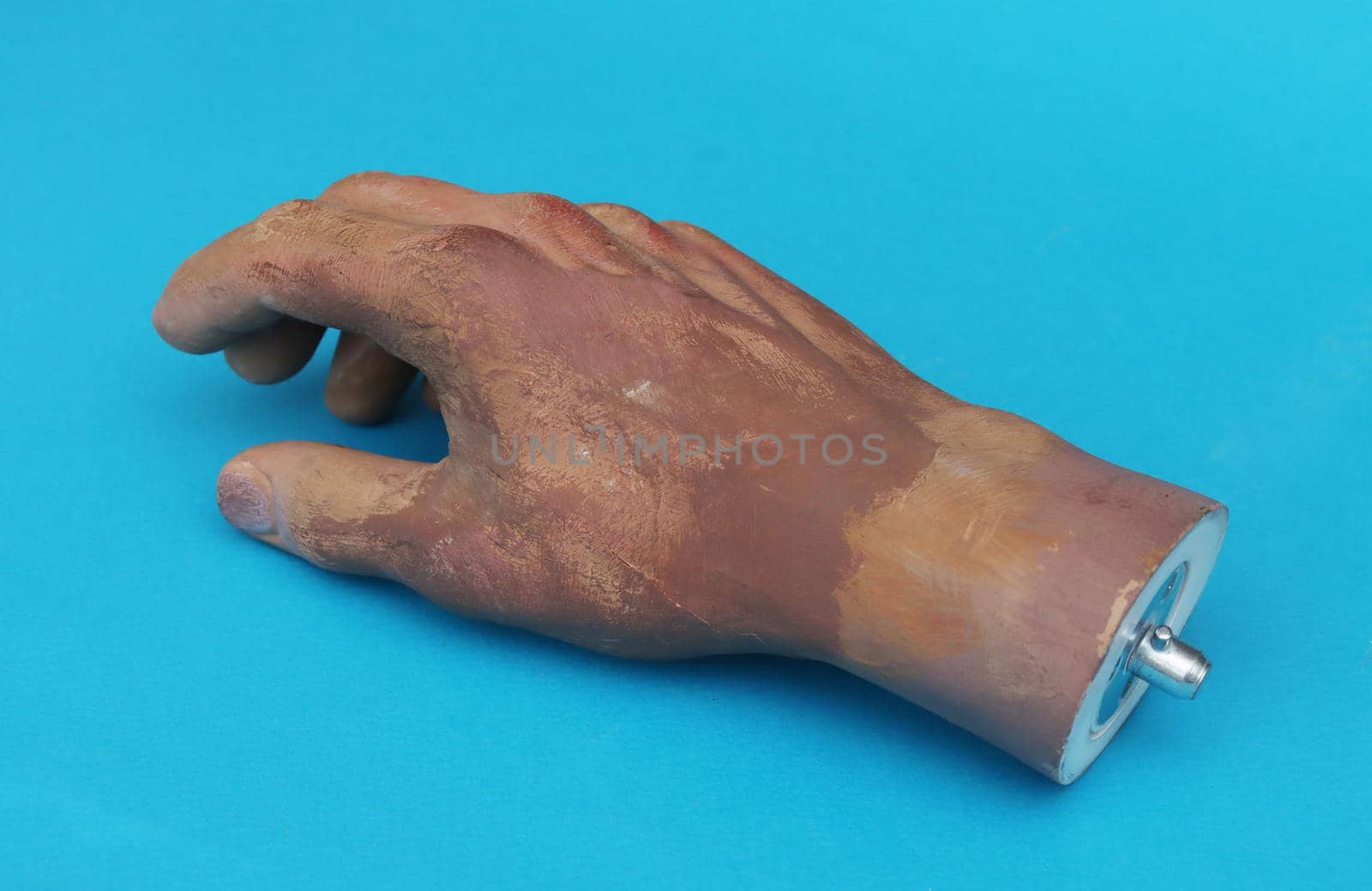 Wrist of man's plastic hand on blue background. by gelog67