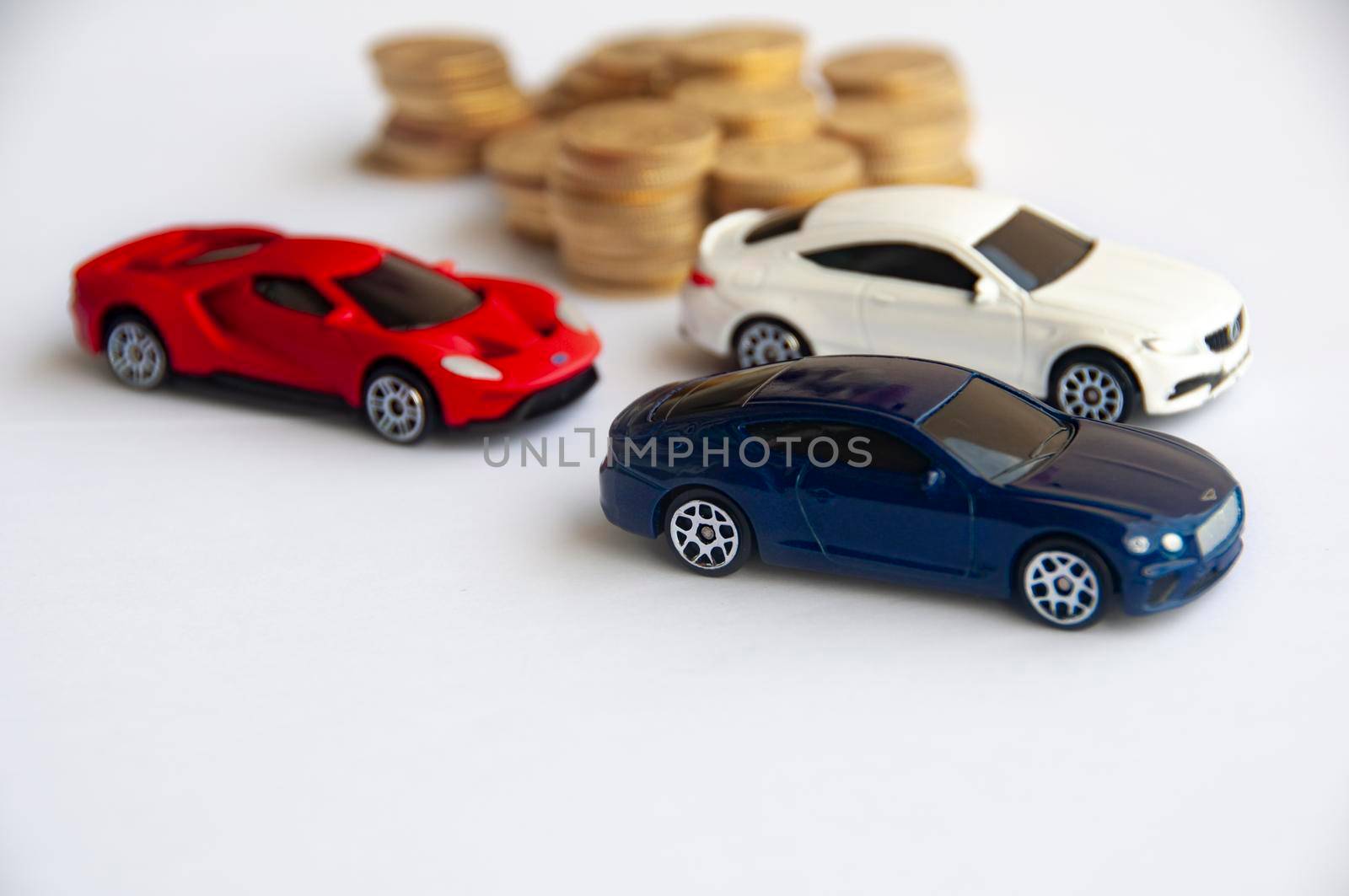 Kuala Lumpur, Malaysia - September 2022 : Miniature toy car of Ford GT, Mercedes AMG and Bentley Continental GT with blurred gold coin background. Copy space.