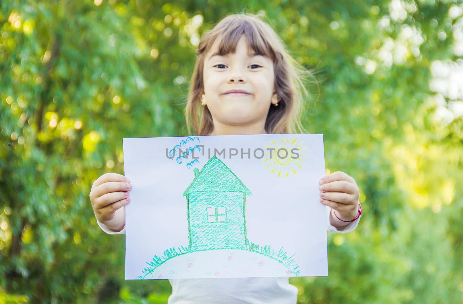 Drawing of a green house in the hands of a child.