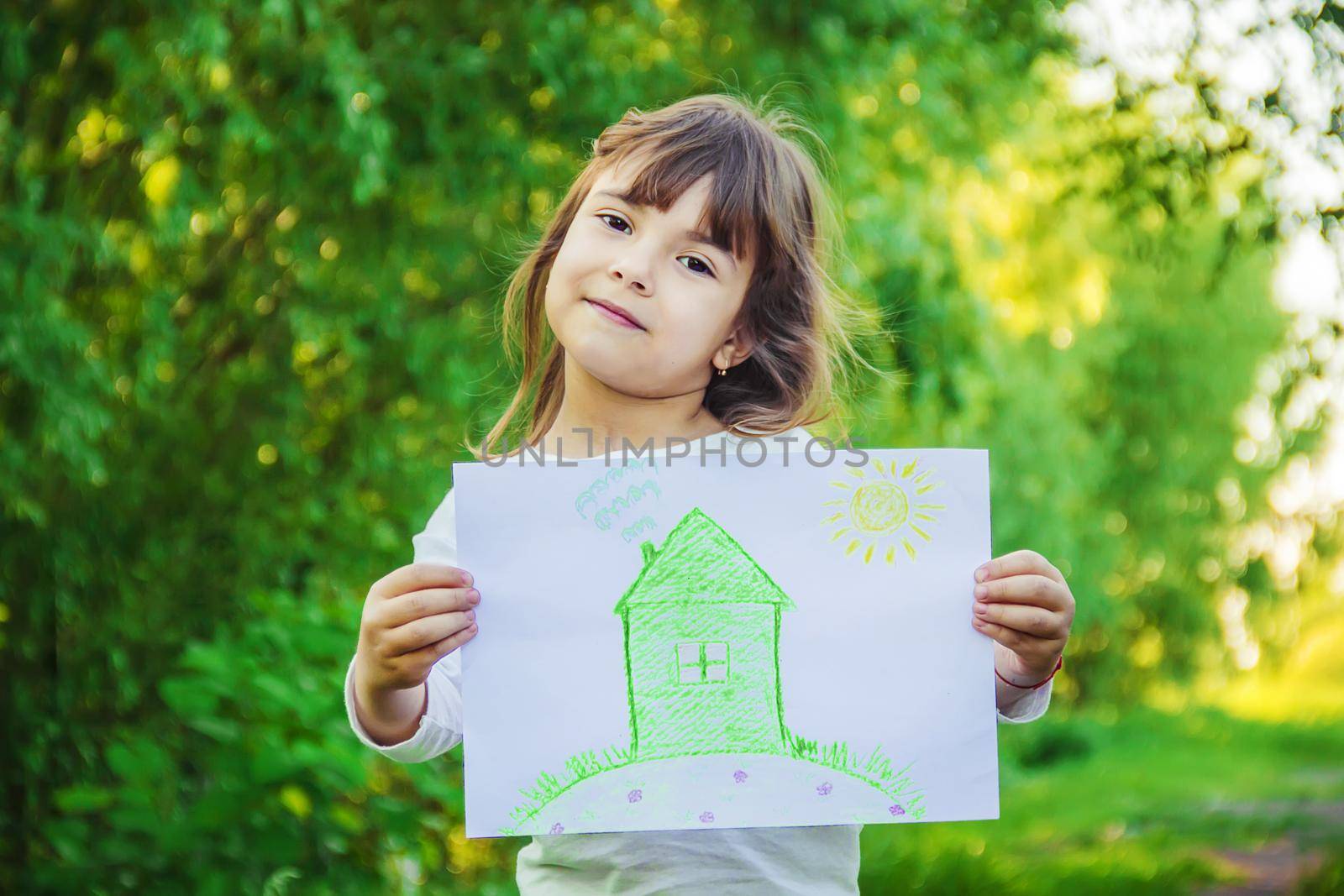 Drawing of a green house in the hands of a child.