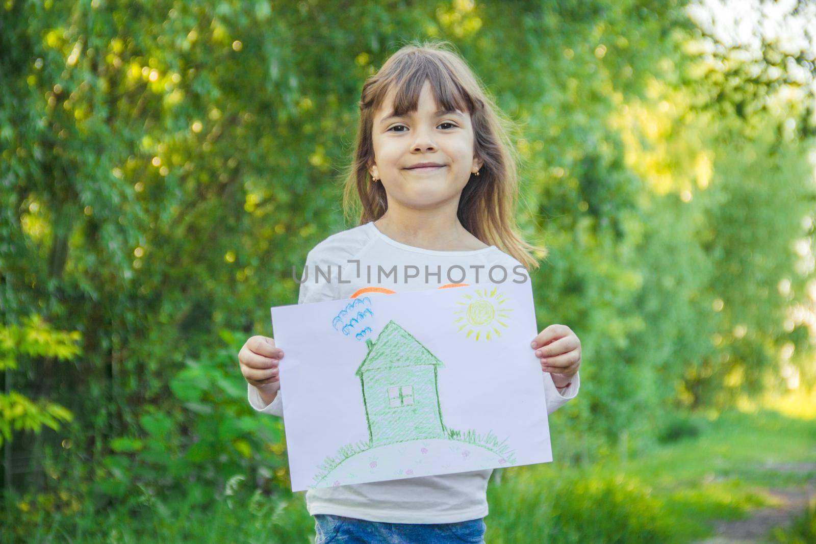 Drawing of a green house in the hands of a child.