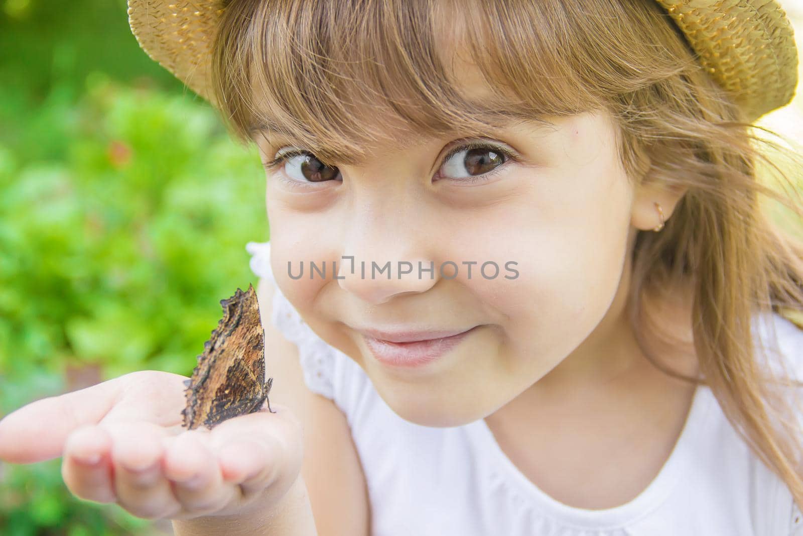 Child with a butterfly. Idea leuconoe. Selective focus. by yanadjana