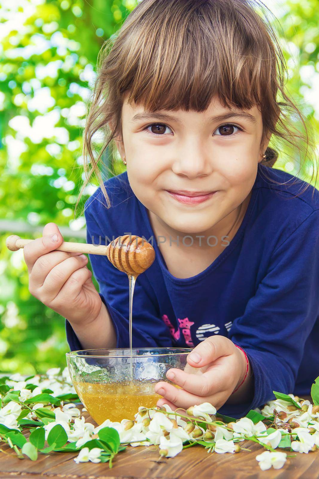 The child eats honey. Selective focus. nature.