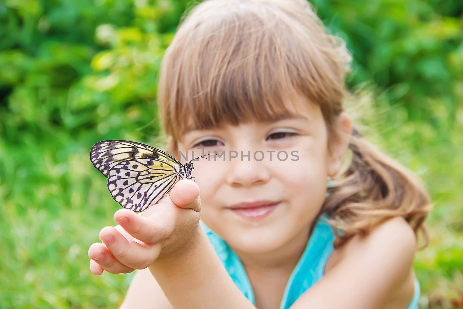 Child with a butterfly. Idea leuconoe. Selective focus.