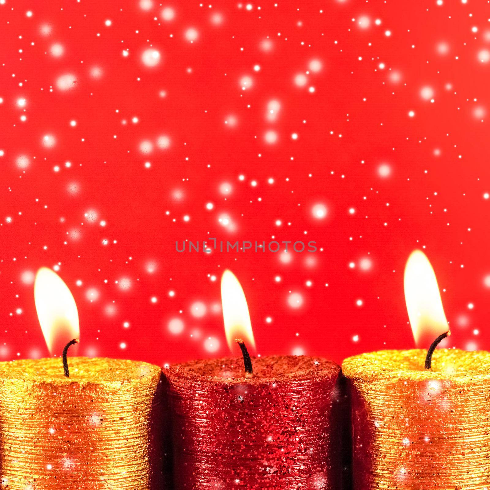 Winter, celebration and new years eve concept - Christmas candles and shiny snow on red background, holiday season decoration
