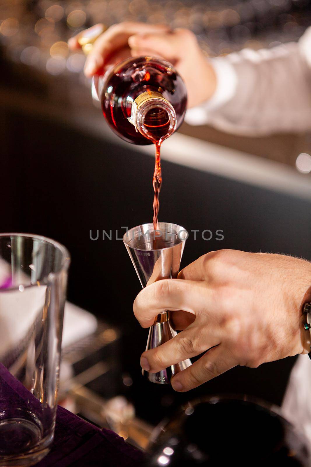 Closeup of bartender hands pouring alcoholic drink.Professional drink making