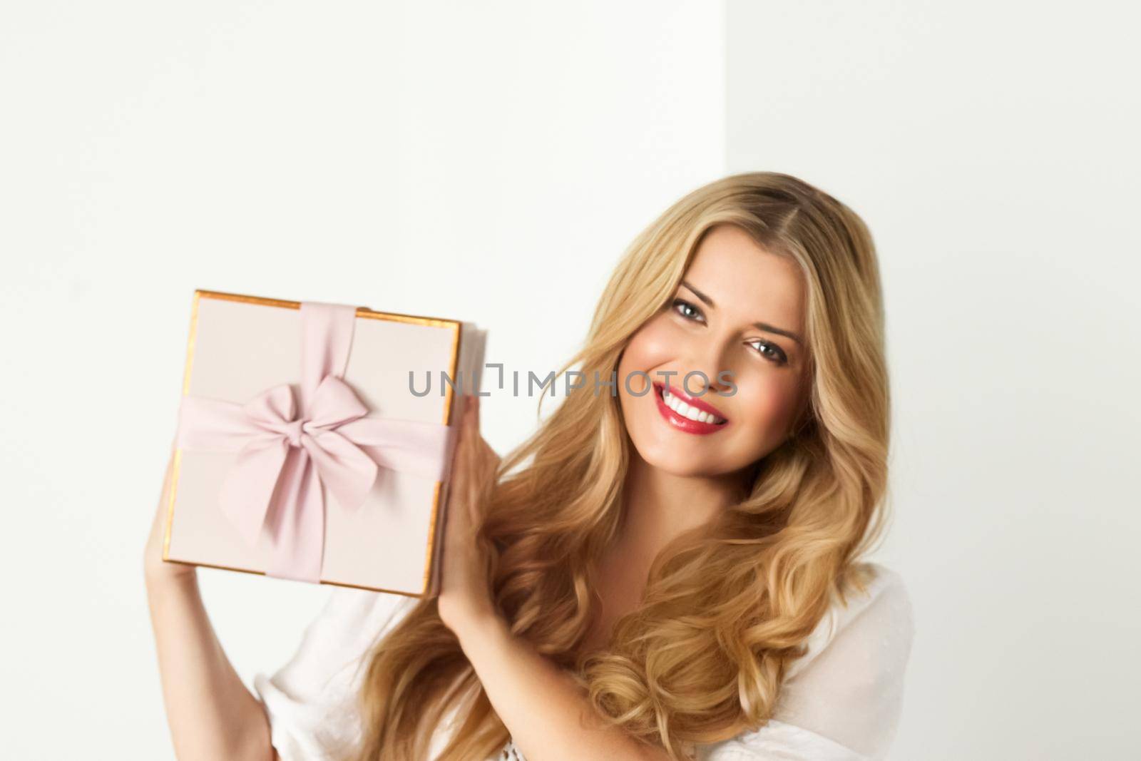 Happy woman holding a gift for birthday, anniversary, wedding, Valentines day or Christmas, luxury holiday present or beauty box subscription delivery concept