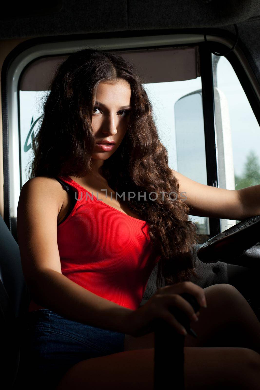 Pretty truck driver with long curls in cabin