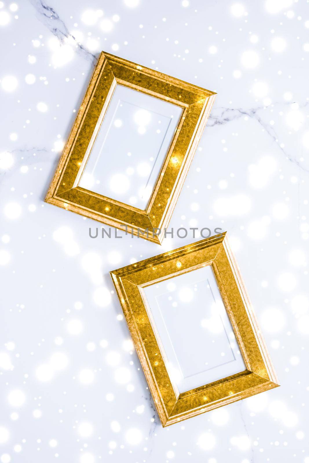 Art gallery, printable poster and online shop mockup concept - Golden photo frame and glowing glitter snow on marble flatlay background for Christmas and winter holidays