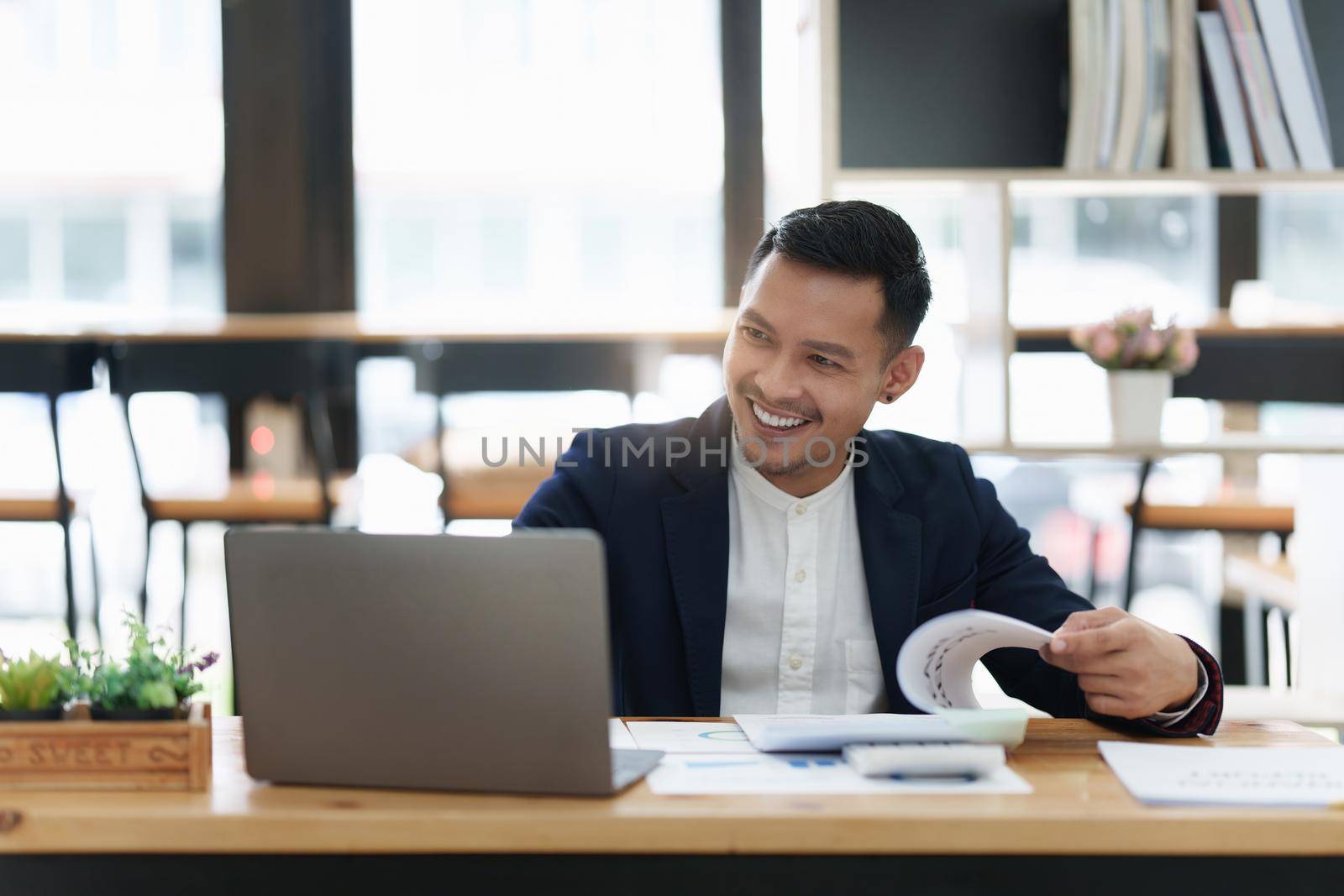 Businessman hand holding pen and pointing at financial paperwork with social network diagram.