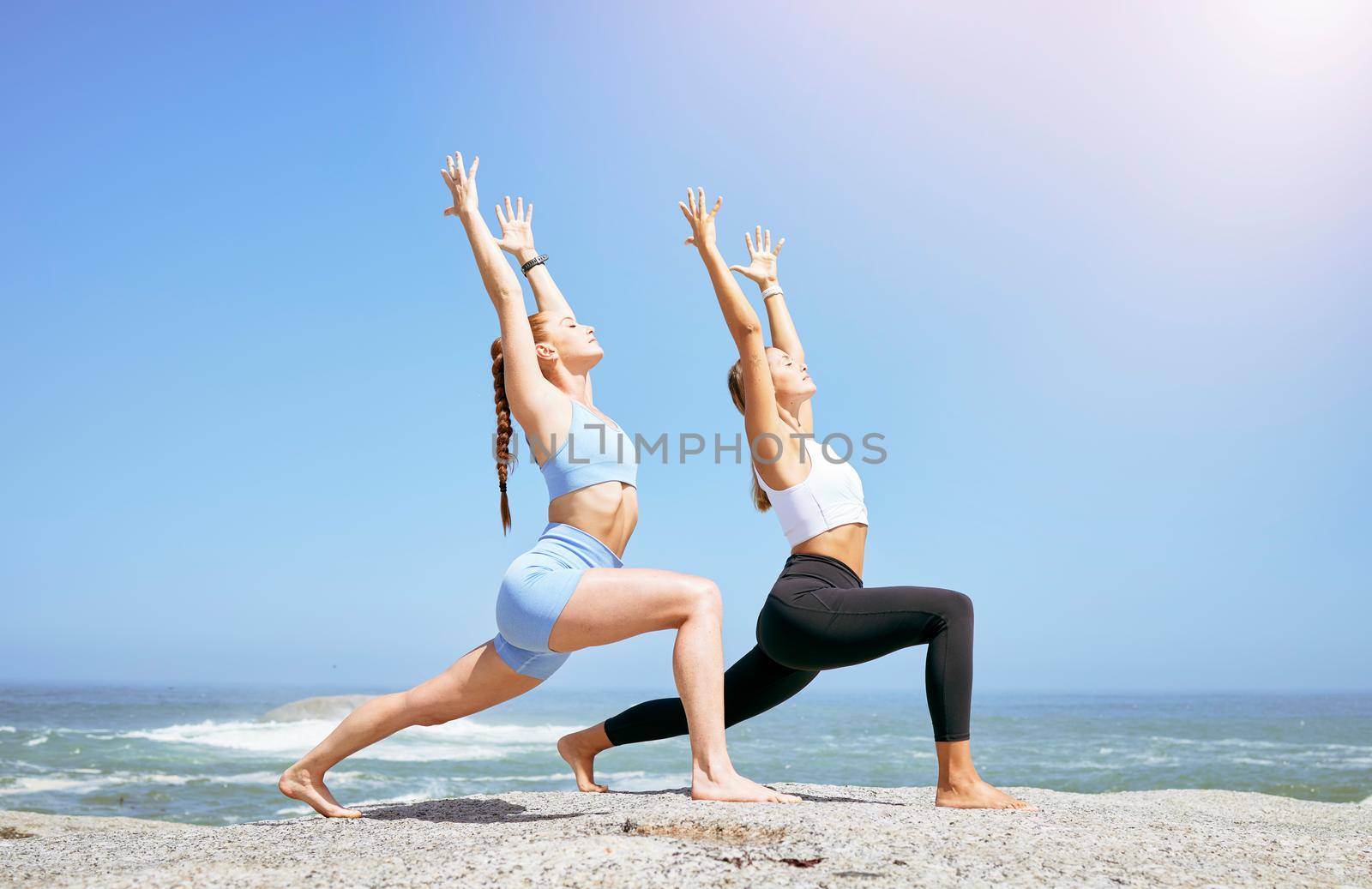 Health, meditation and women doing yoga at beach, mediation and fitness training in summer together. Peace, energy and friends exercise and bond while stretching in the sun and enjoying the ocean by YuriArcurs