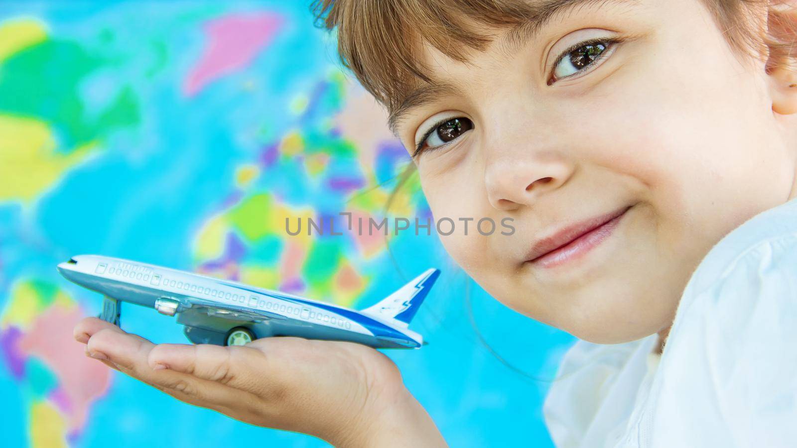 The plane is in the hands of the child. Selective focus. by yanadjana