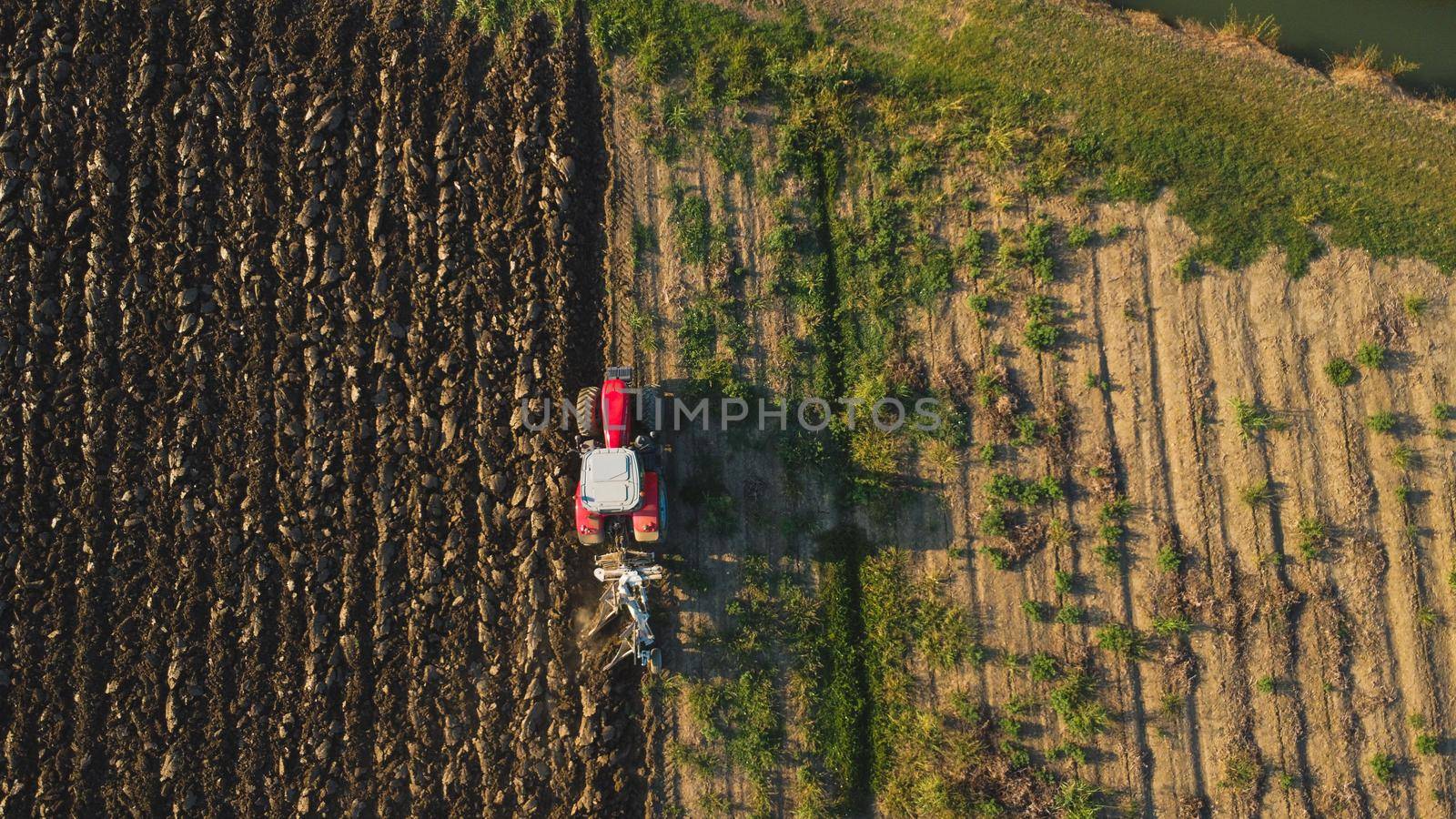 Aerial view with drone of tractor plowing the land in the countryside.