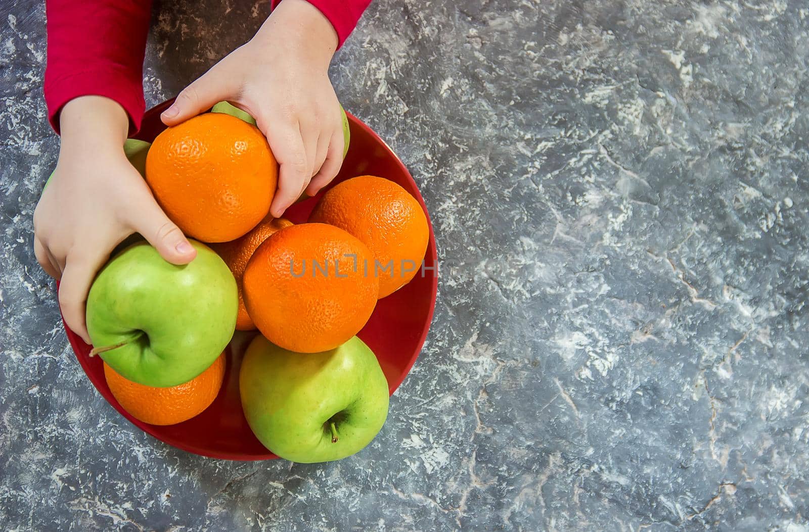 apples and oranges in the hands of a child. by yanadjana