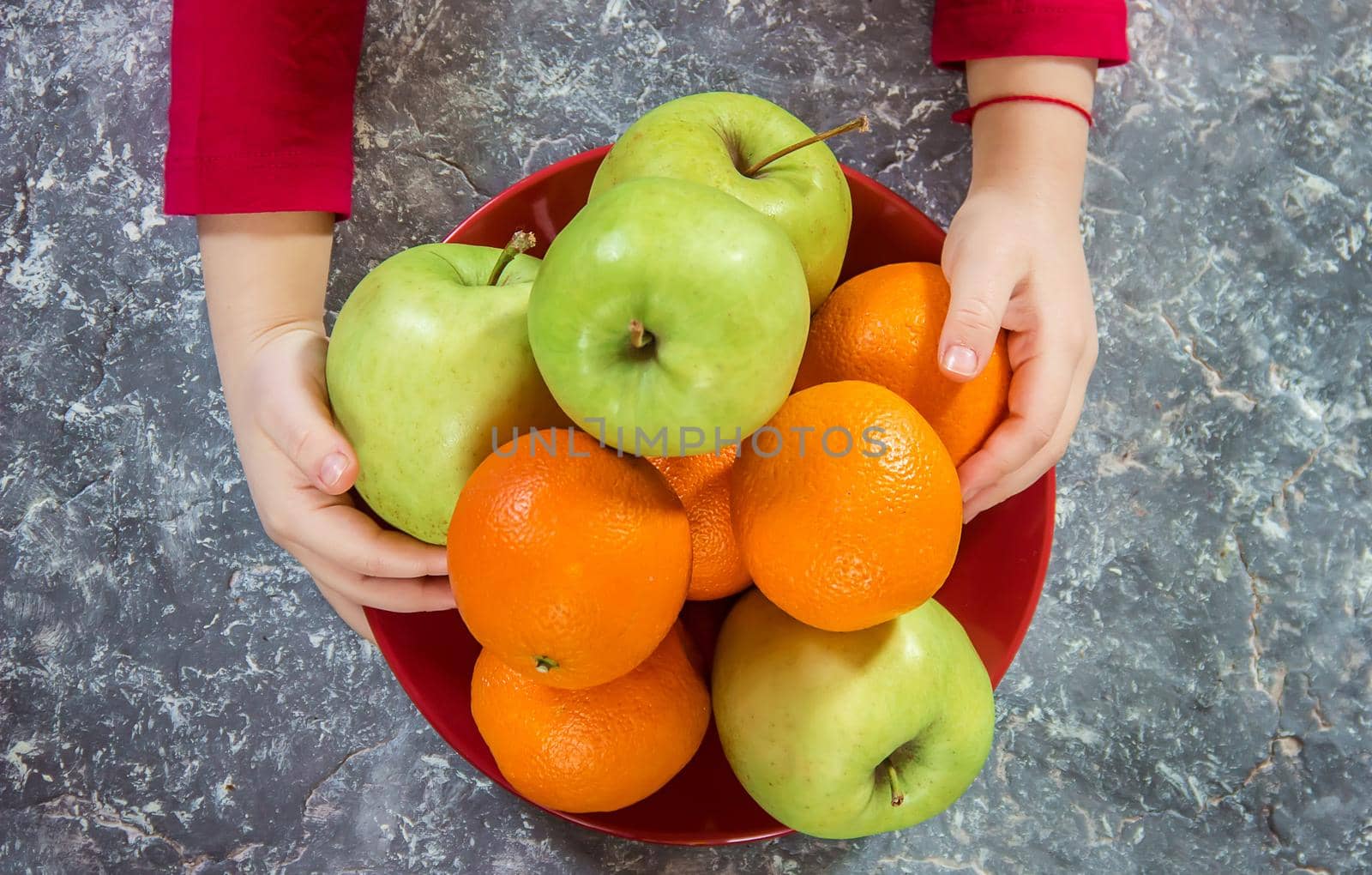 apples and oranges in the hands of a child. by yanadjana