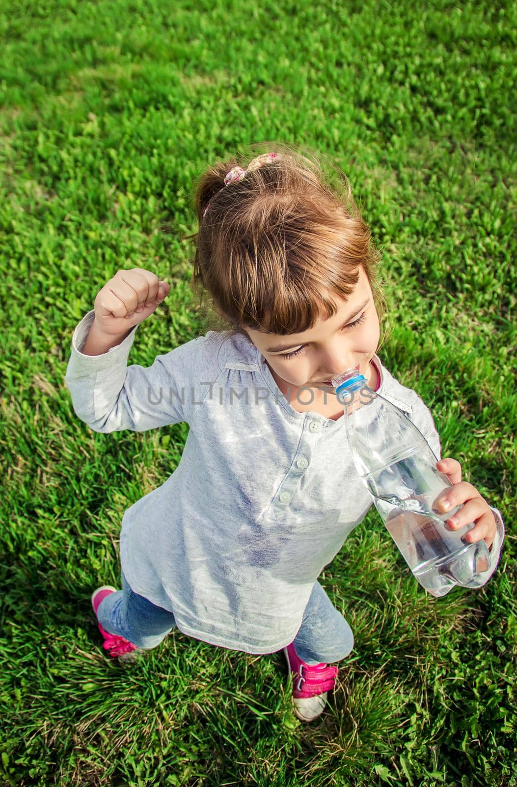 Baby drinks water from bottle. selective focus. by yanadjana