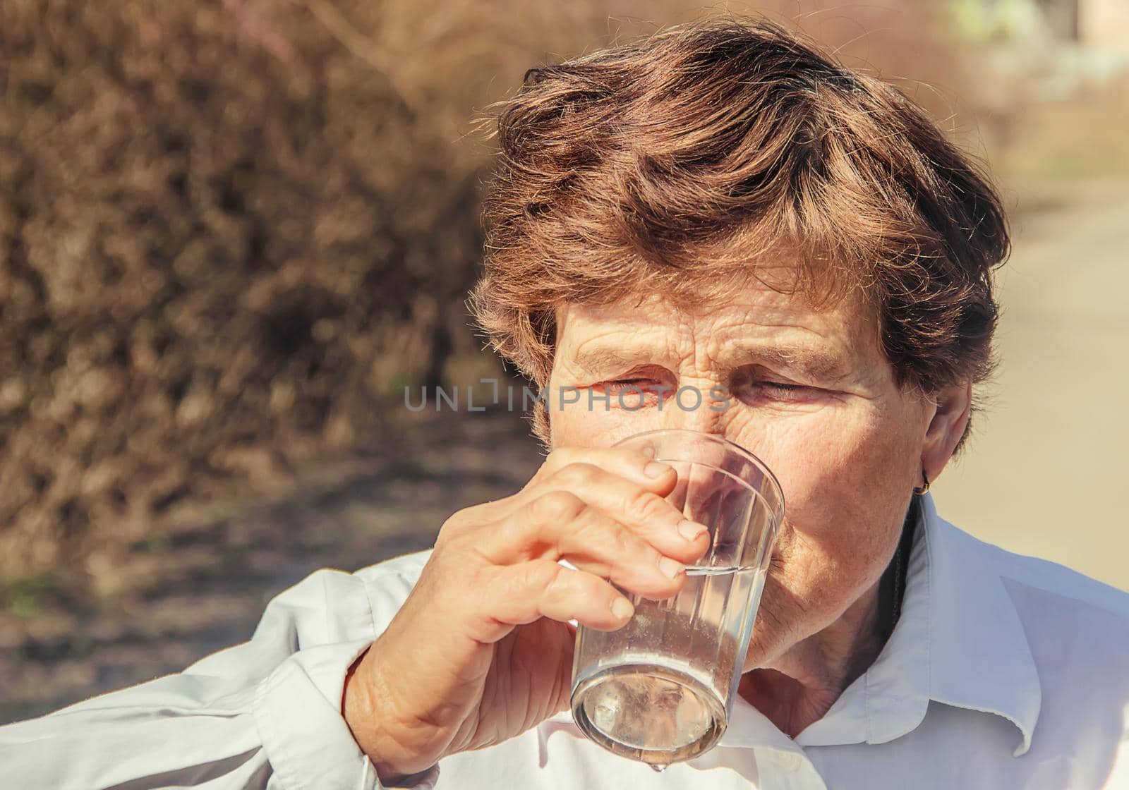 Grandmother giving a glass of clean water to a child. Selective focus.
