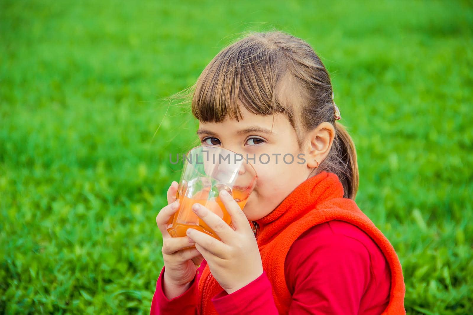 Child on a picnic with juice and fruit. Selective focus.