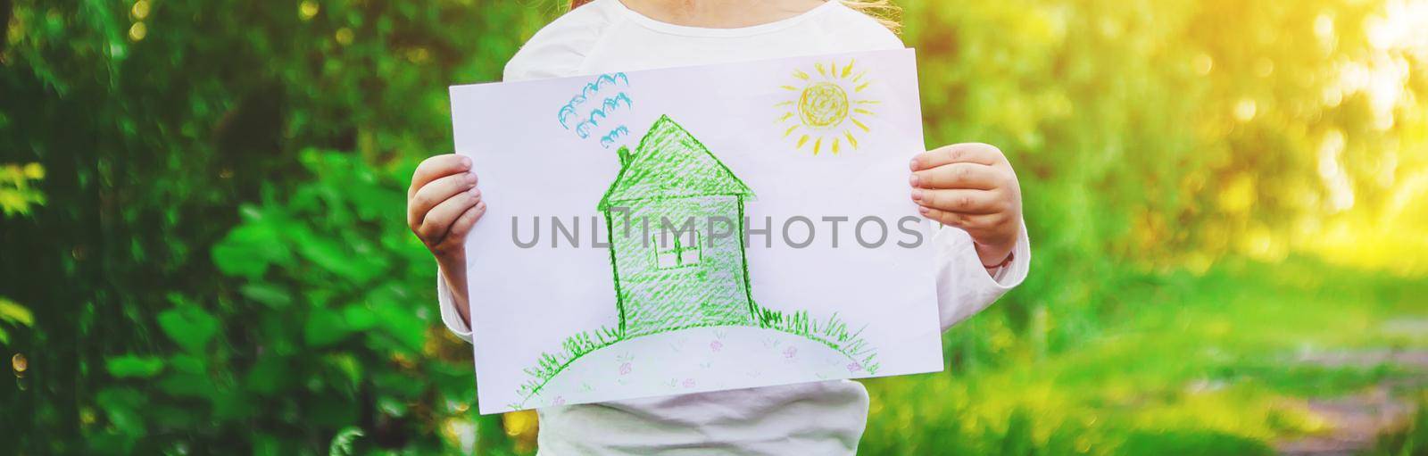 Drawing of a green house in the hands of a child.