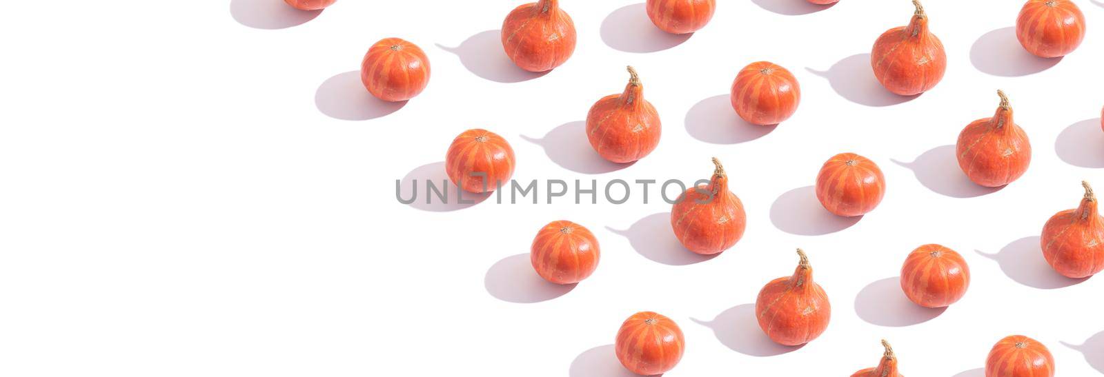 Pattern made from orange pumpkins. Creative autumn banner with copy space.