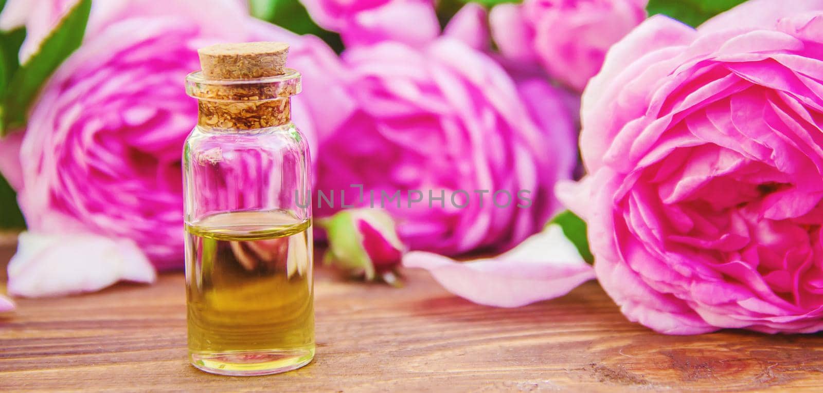 Essential oil of rose on a light background. Selective focus.