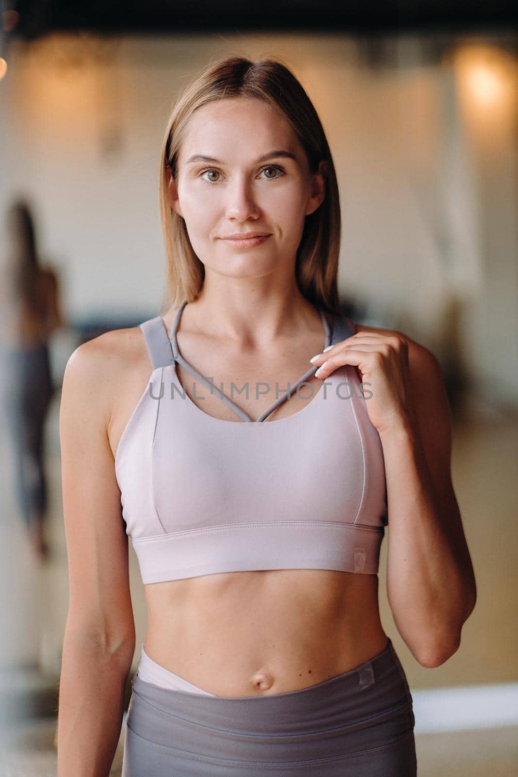 Portrait of a girl in the gym. A coach in sportswear is standing in the gym.