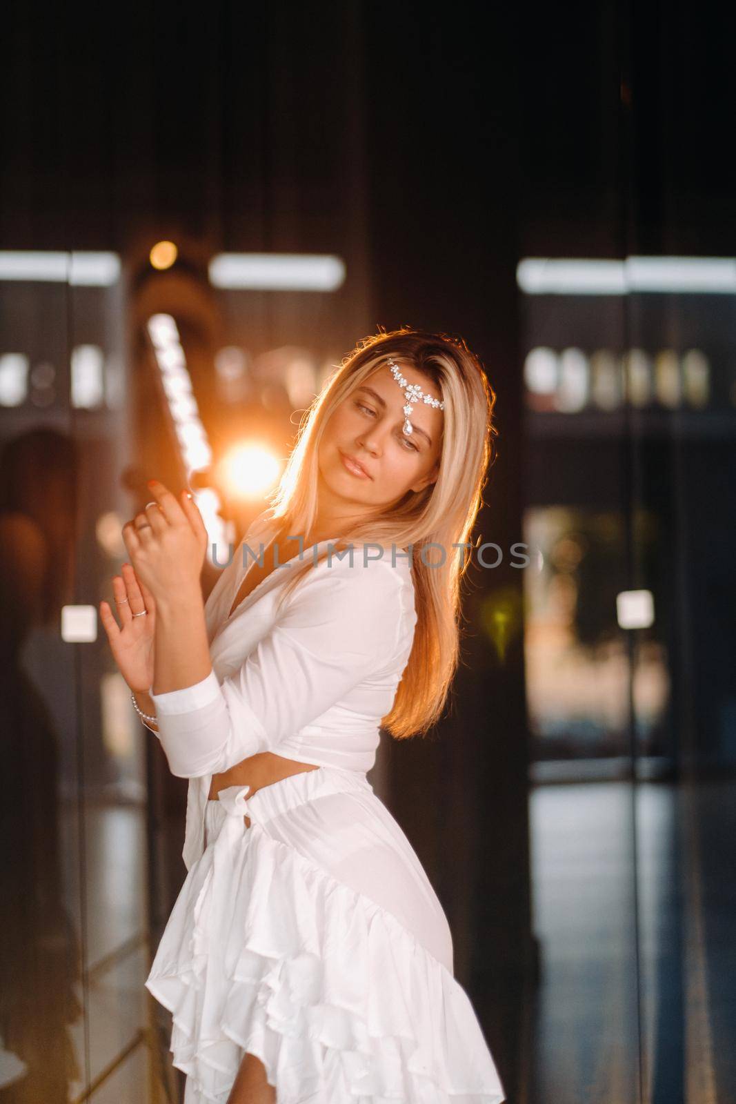 Beautiful smiling girl in a white dress dancing in the gym.