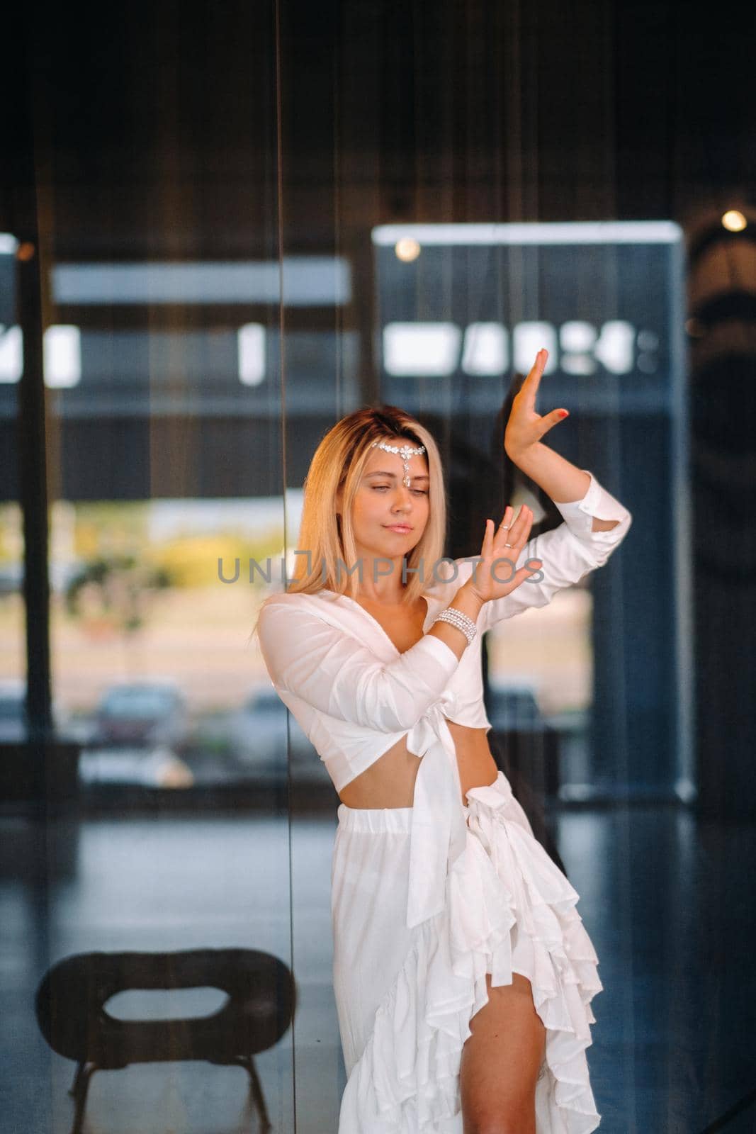 Beautiful smiling girl in a white dress dancing in the gym.