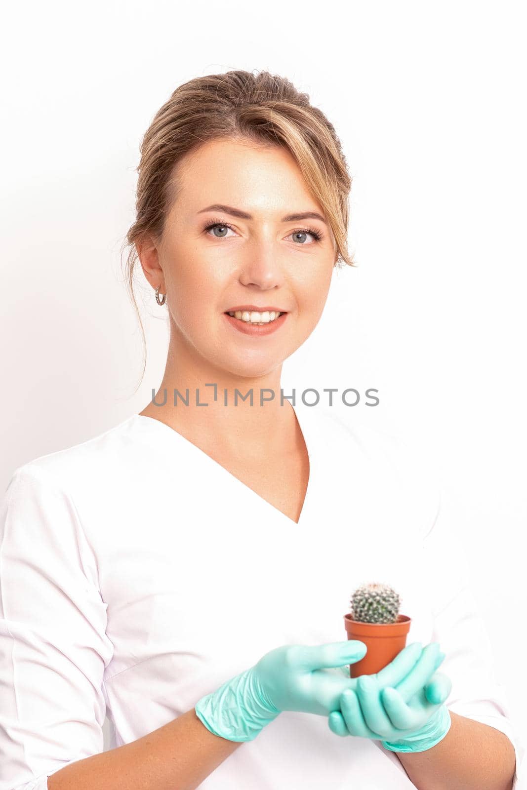 A portrait of a smiling female holds little green cactus in her hands. Hair removal concept