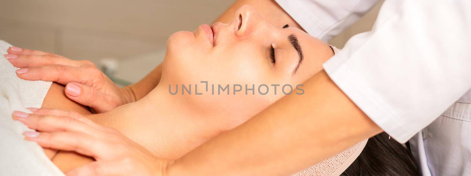 Young caucasian woman with closed eyes getting a chest massage in a beauty clinic. by okskukuruza