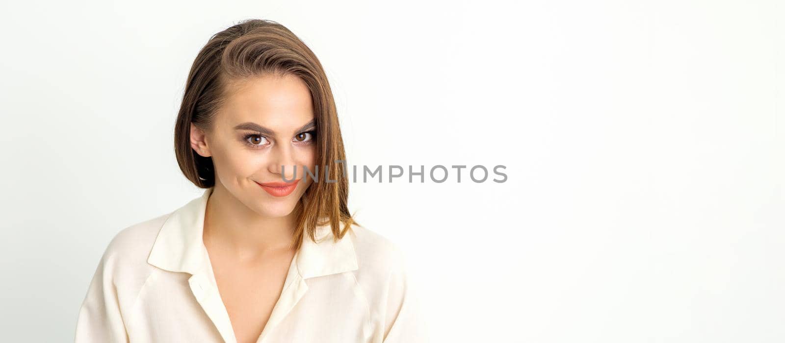 Portrait of a beautiful young caucasian smiling brunette woman with long straight hair standing and looking at the camera on white background
