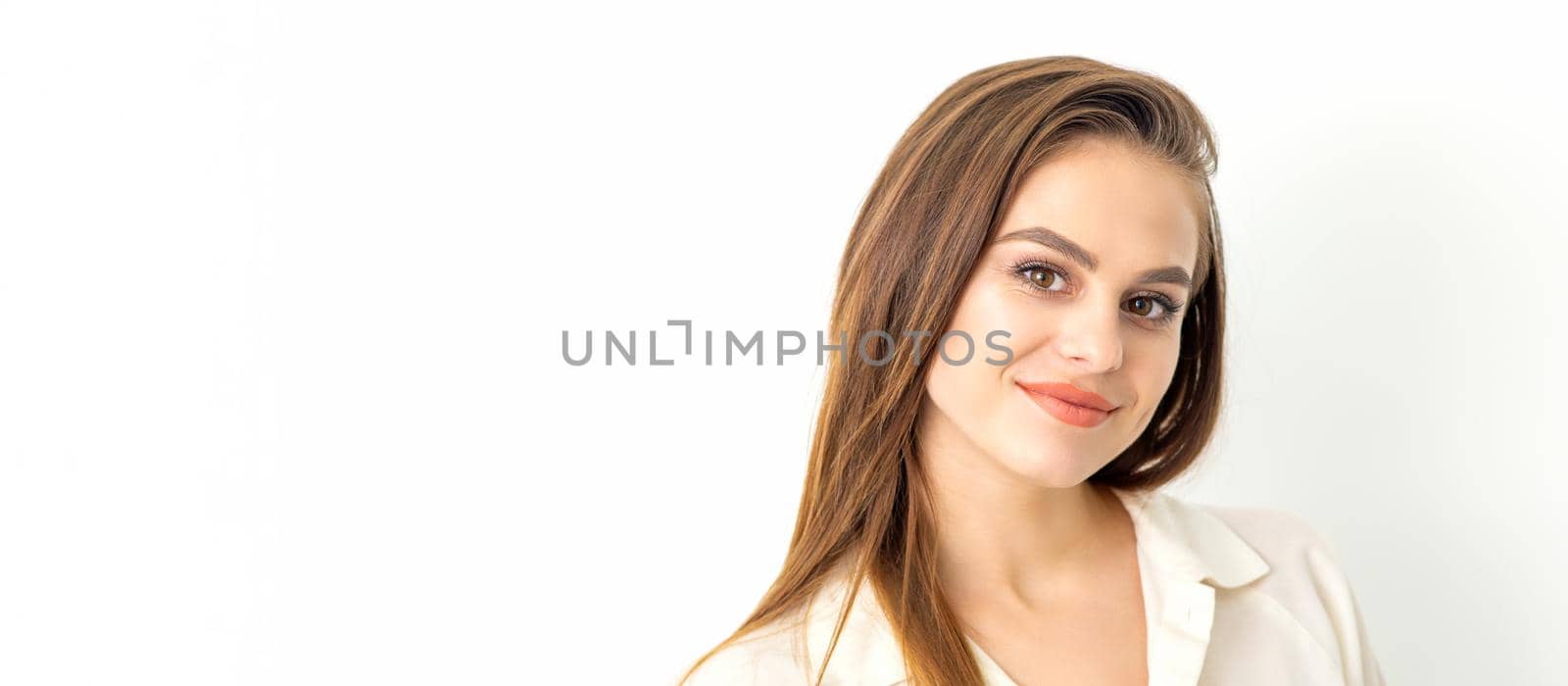 Portrait of a beautiful young caucasian smiling brunette woman with long straight hair standing and looking at the camera on white background. by okskukuruza