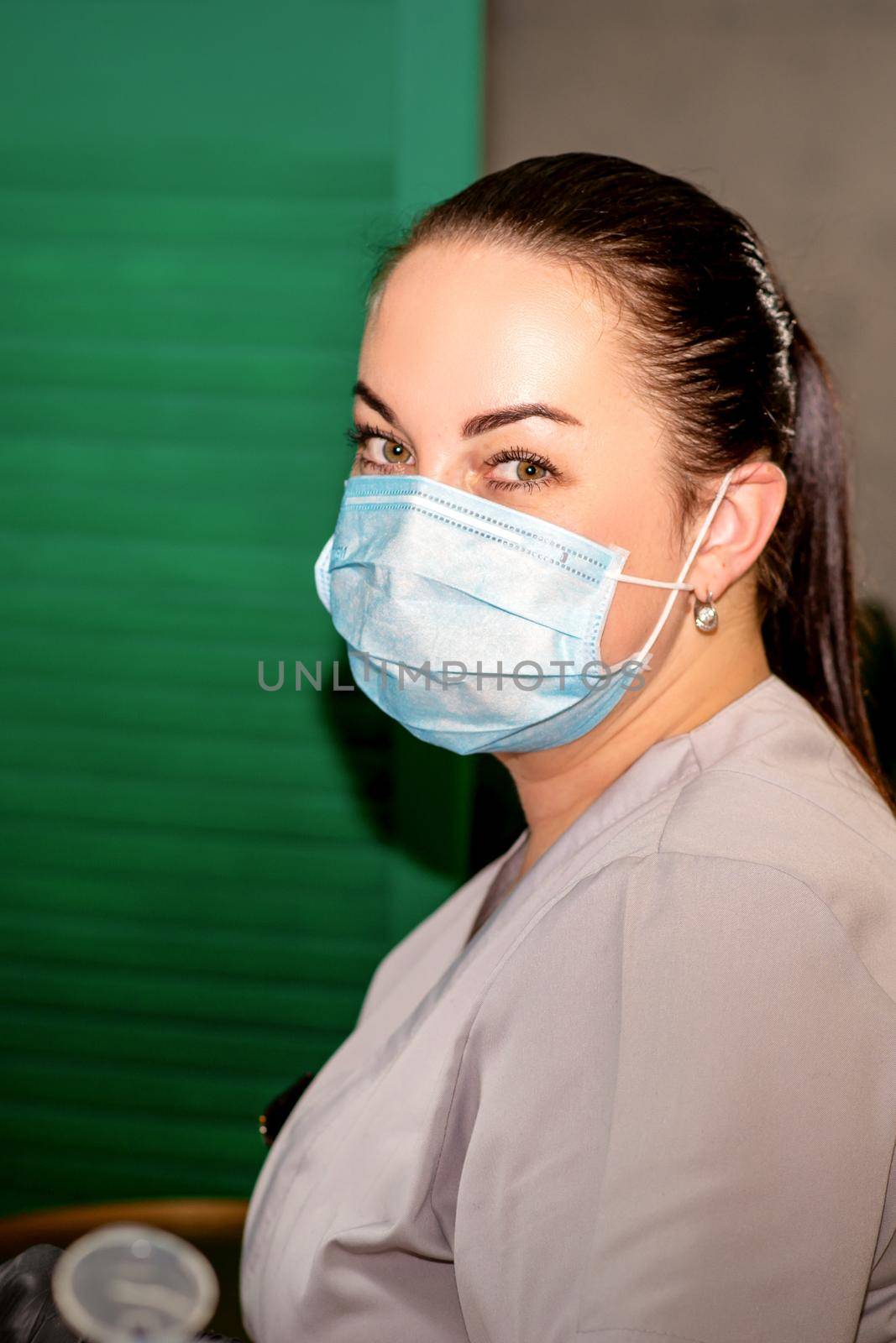 Young female podiatrist with a protective mask looking at the camera in her podiatry clinic
