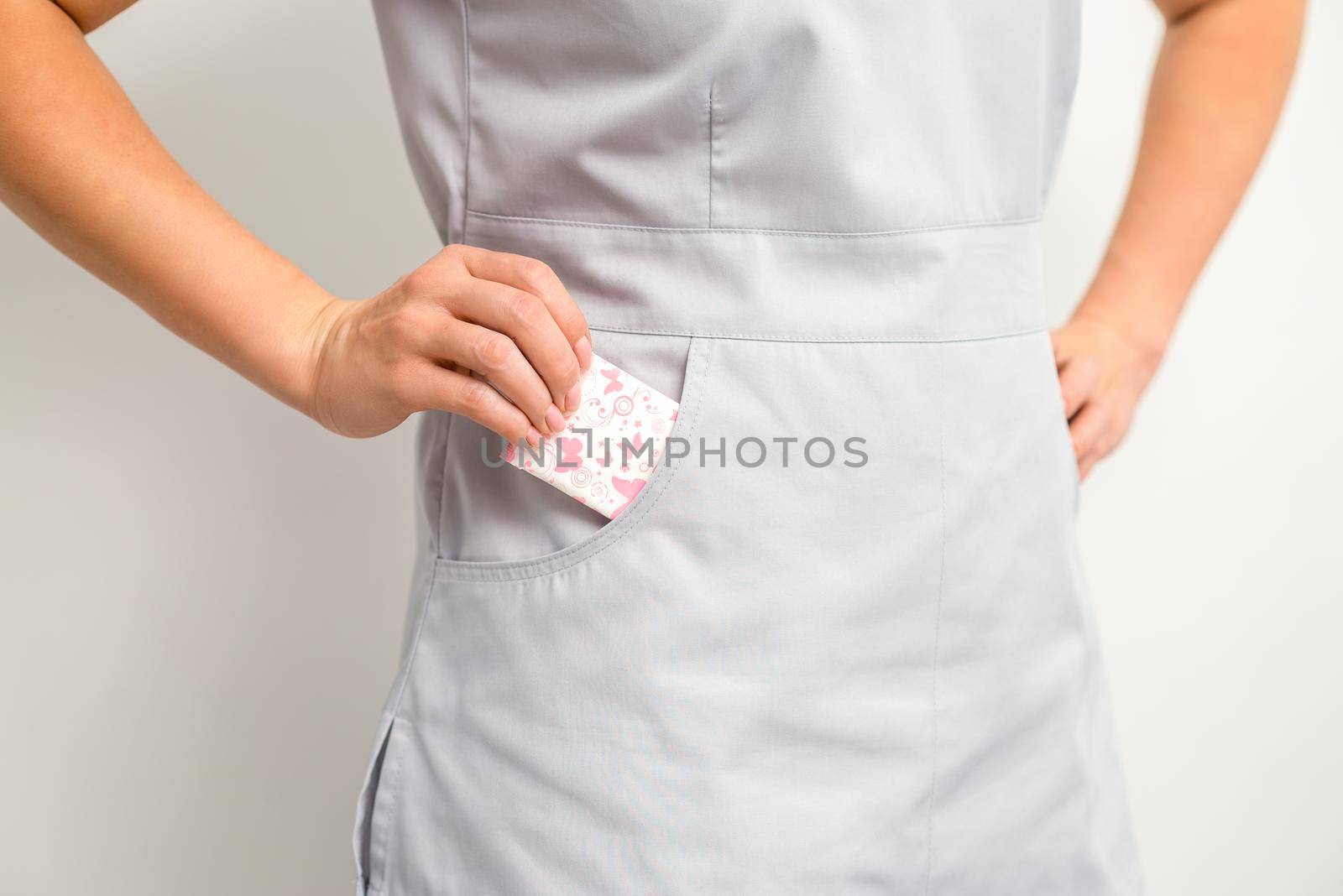 The female hand puts menstrual sanitary pads into her pocket, close up. by okskukuruza