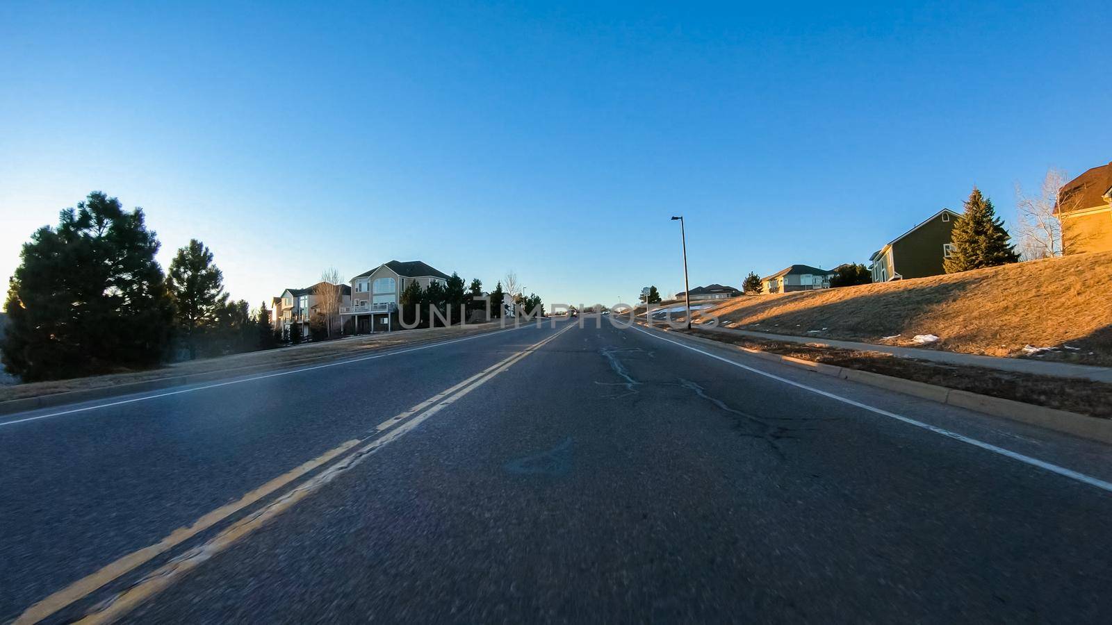 Driving on typical paved roads in a suburban upscale residential neighborhood of America.