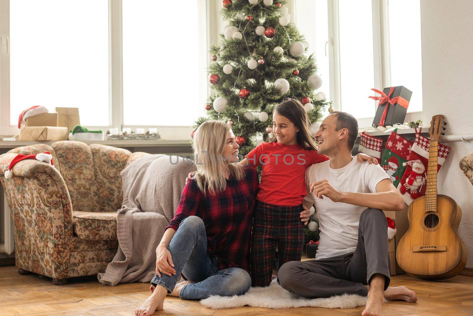 Christmas family. Happy mom, dad and little daughter. Enjoyng love hugs, holidays people. Togetherness concept.