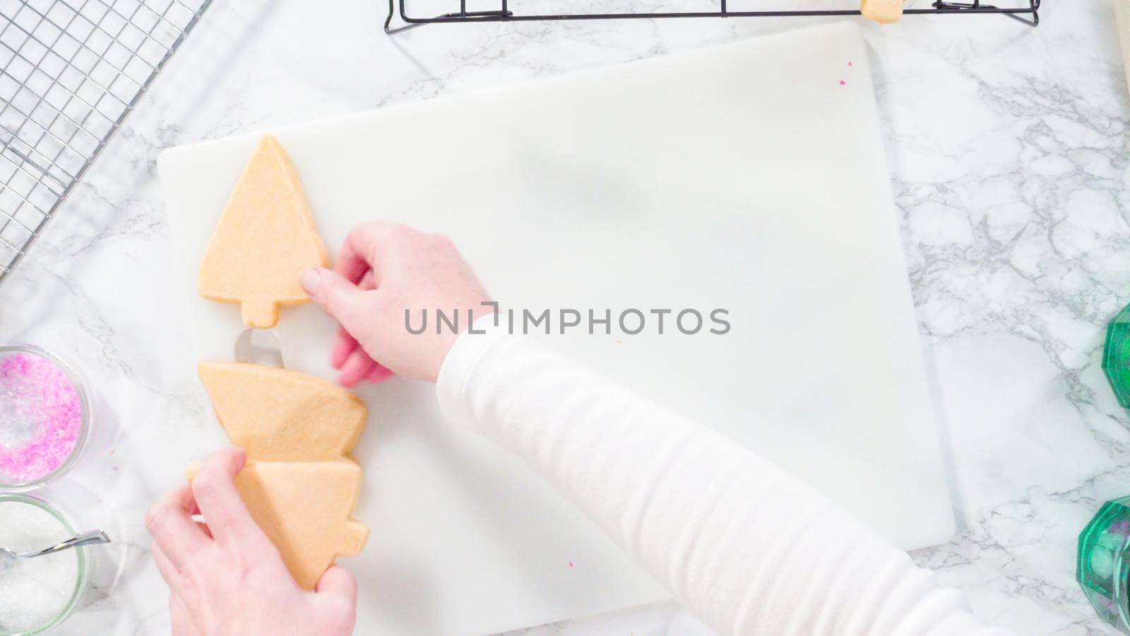 Flat lay. Stp by step. Icing Christmas tree-shaped sugar cookies with green royal icing.