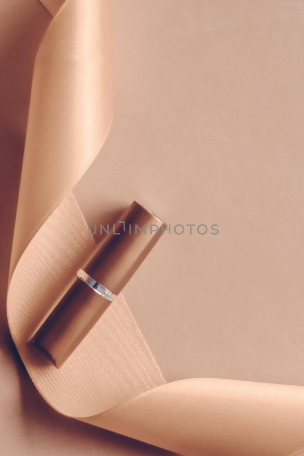 Cosmetic branding, glamour lip gloss and shopping sale concept - Luxury lipstick and silk ribbon on beige holiday background, make-up and cosmetics flatlay for beauty brand product design