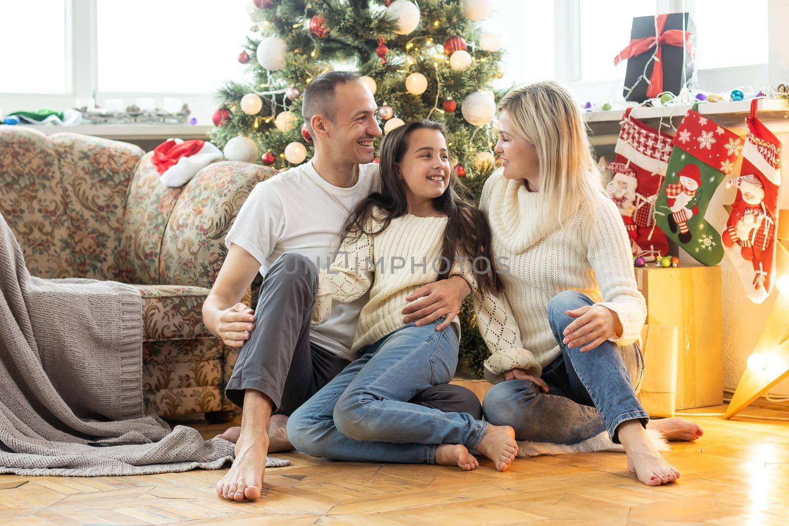 Christmas. Family. Happiness. Top view of dad, mom and daughter on the floor at home. by Andelov13