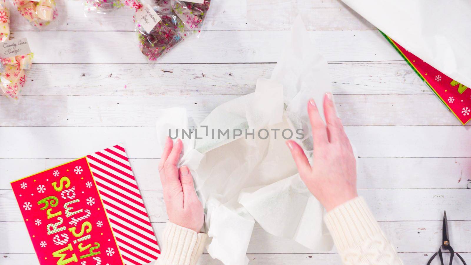 Flat lay. Step by step. Packaging homemade fudge and cookies into a Christmas gift box.