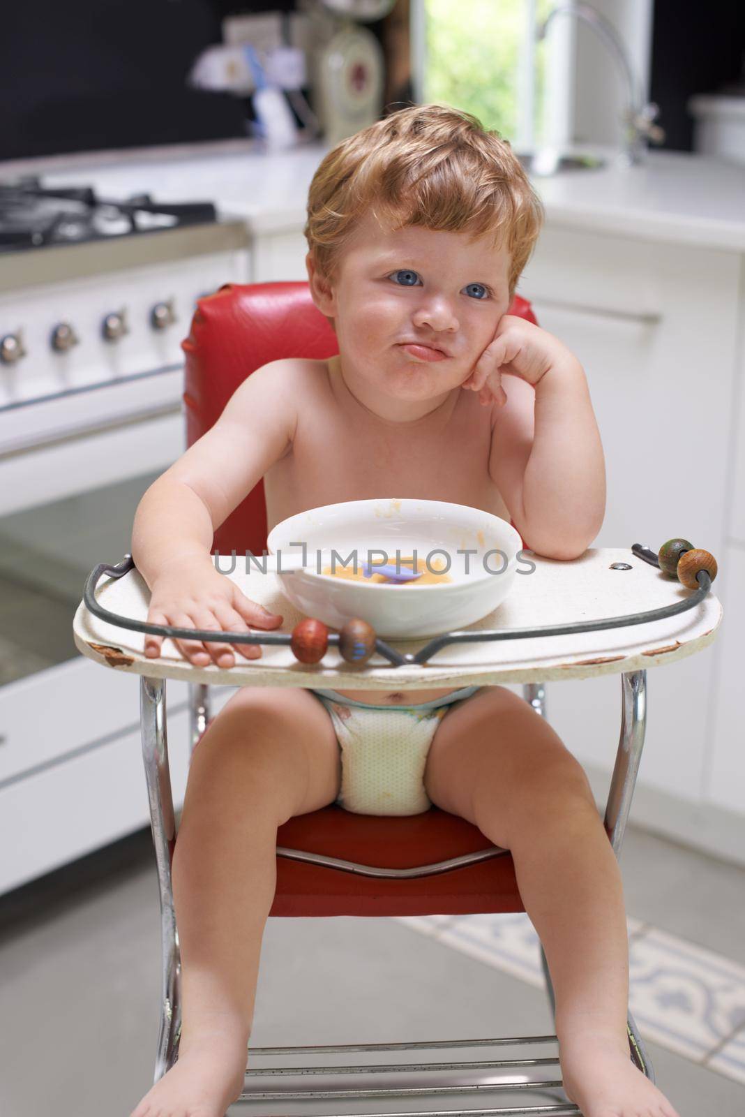 I wish someone would let me out...A bored toddler sitting in a high chair. by YuriArcurs