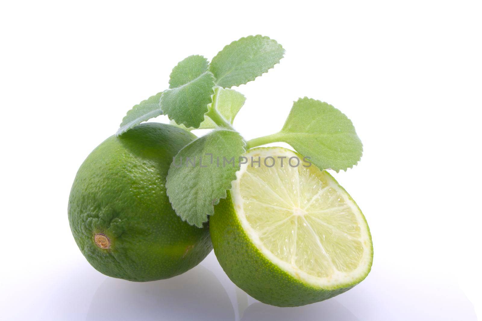 Fresh, natural, green limes, cut in half and whole, fresh mint on a white background.