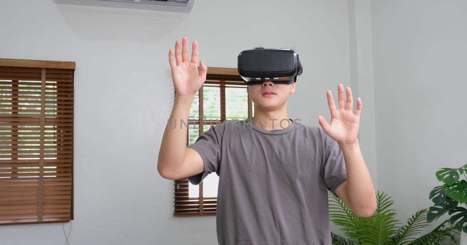 young asian man touching the air during the VR experience.