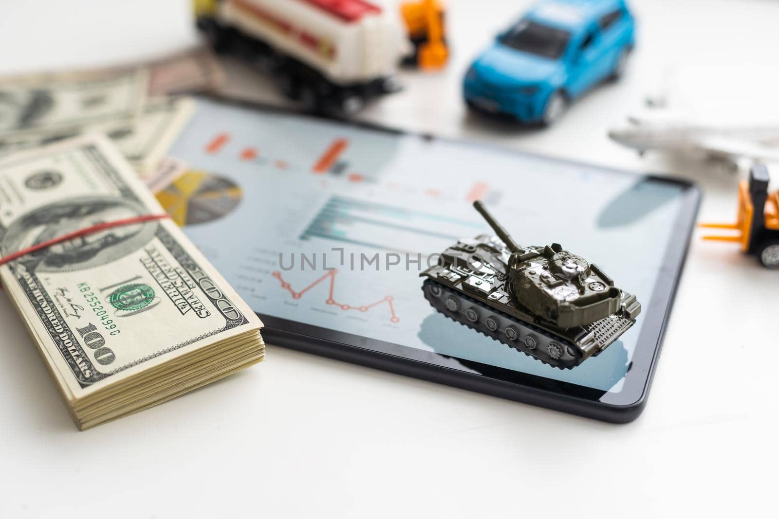 a toy tank, dollars and a tablet by Andelov13