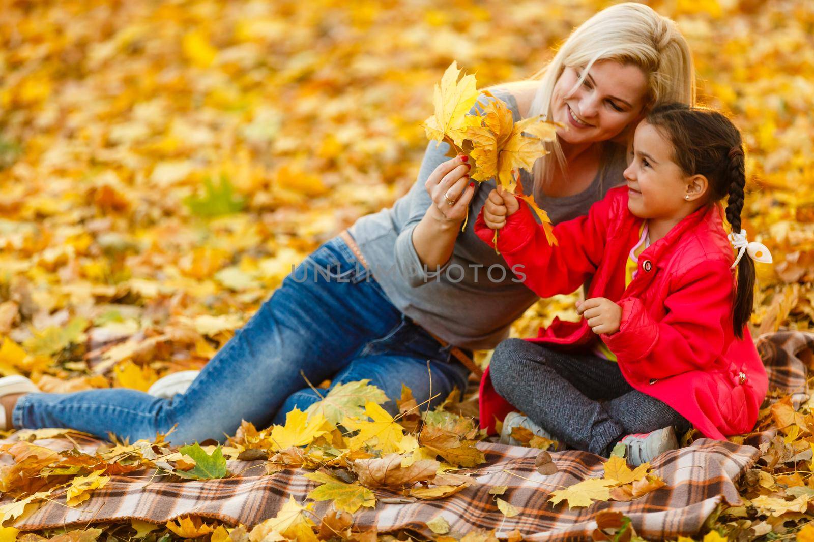 happy family mother and child daughter playing and laughing on autumn walk. by Andelov13