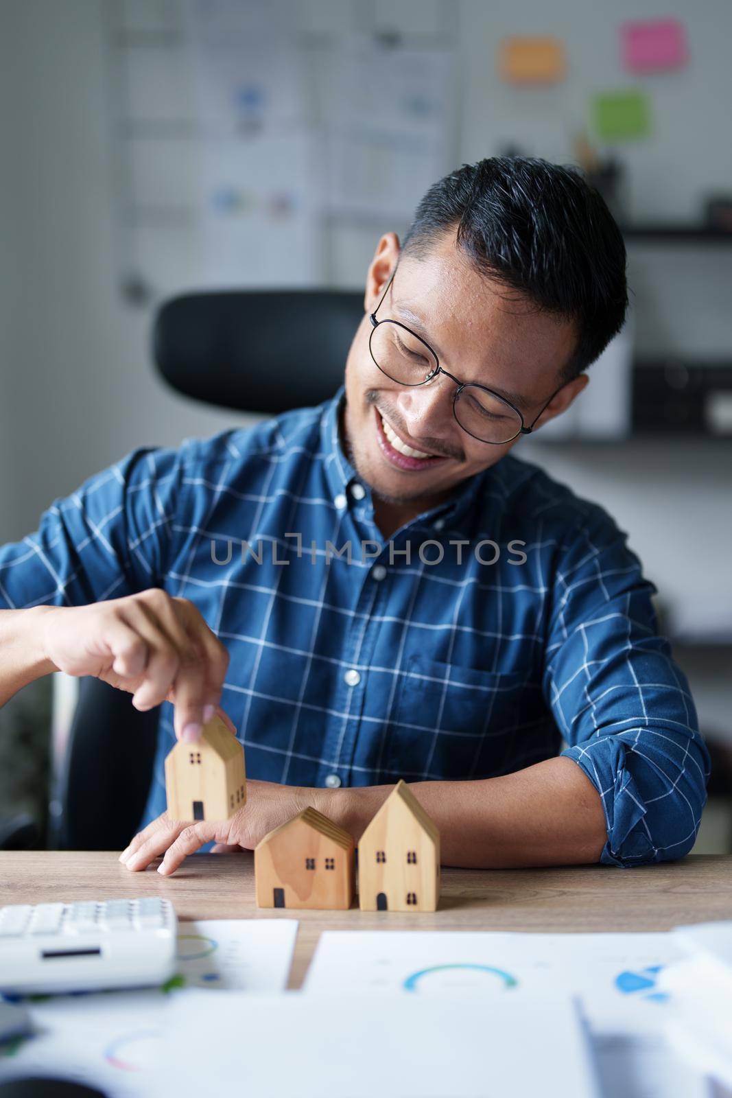 Entrepreneurs, business owners, accountants, real estate agents, A young man using a calculator to calculate his home budget to assess the risks of investing in real estate.