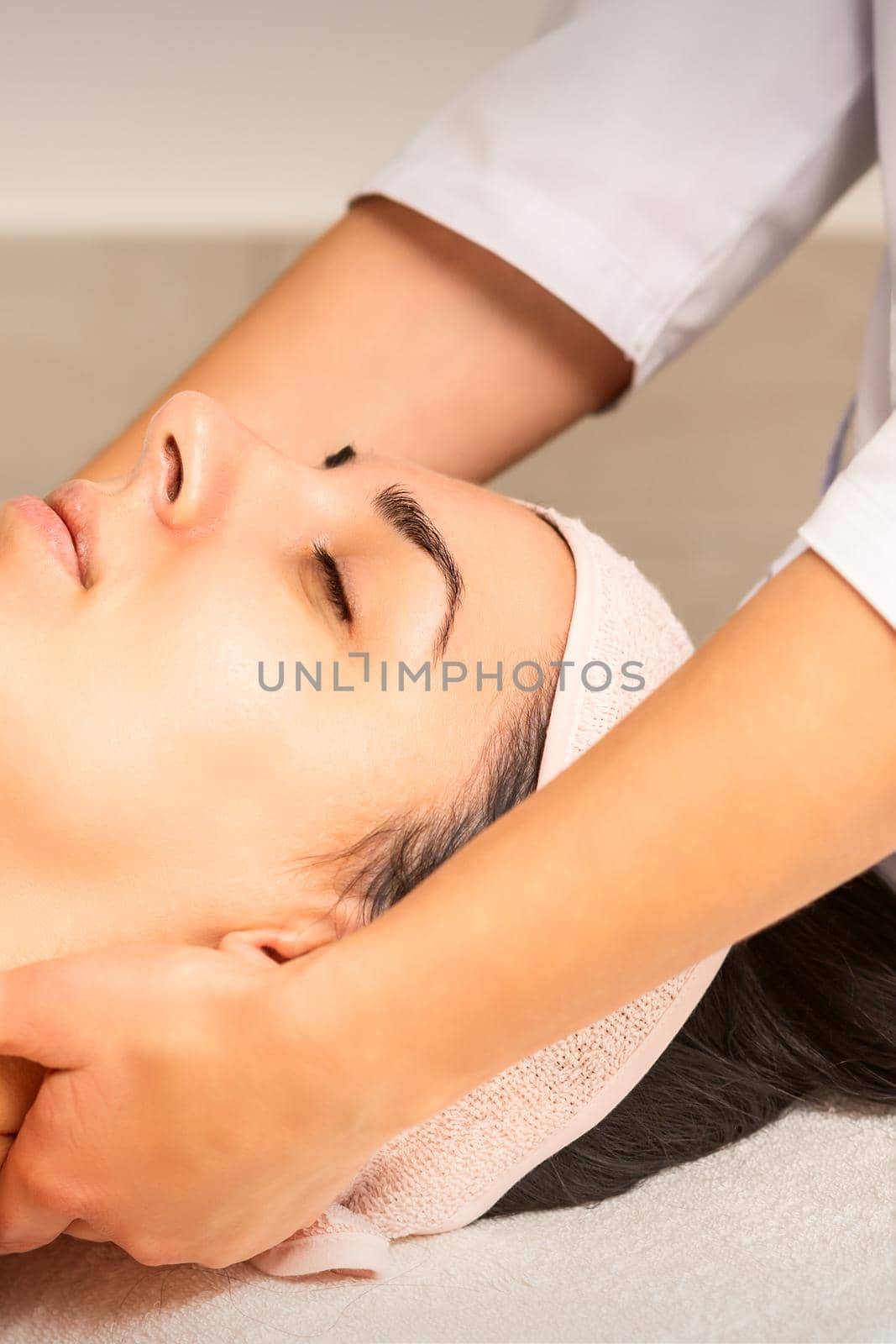 Facial massage. Young caucasian woman getting a massage on her neck in a beauty clinic