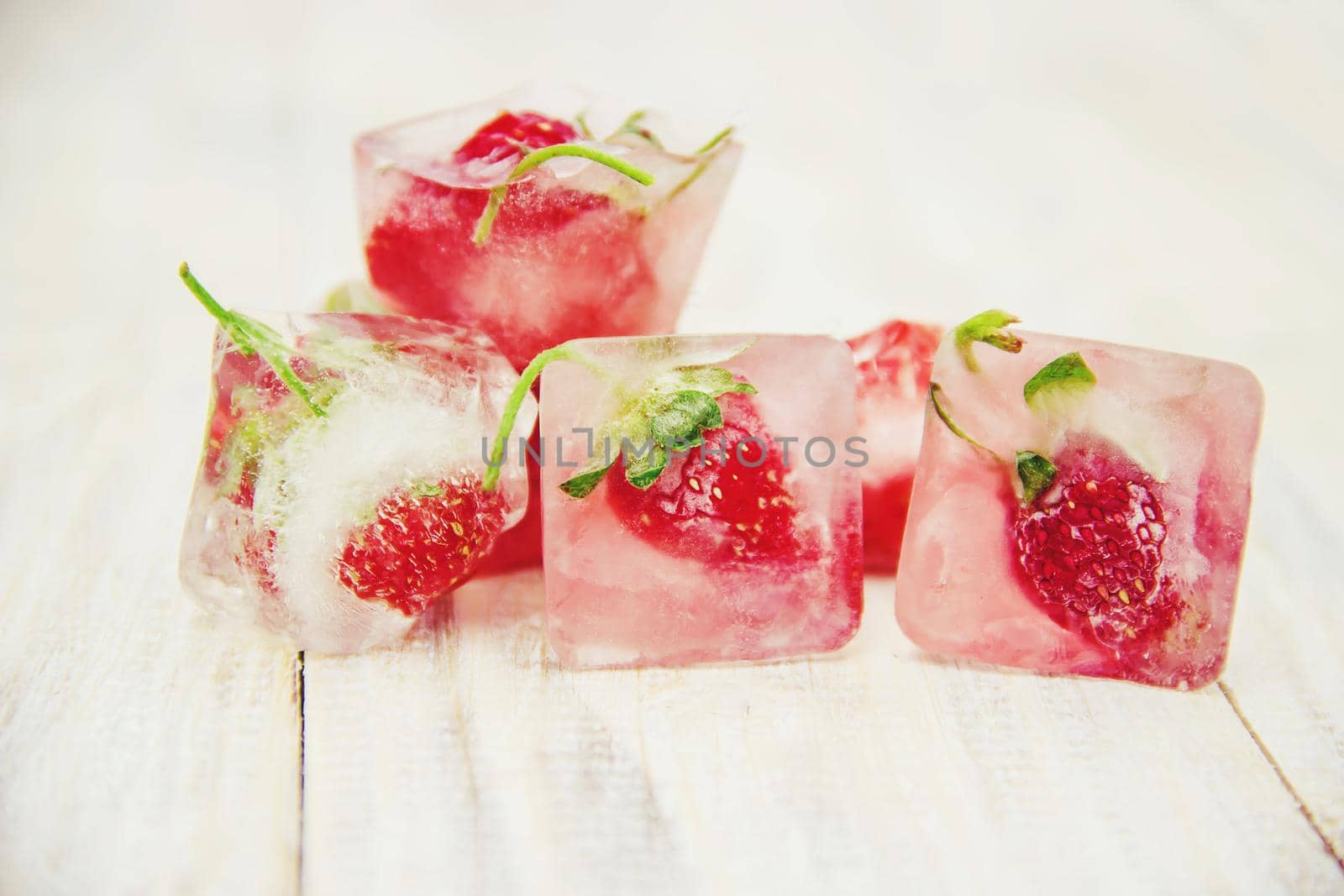 Berries frozen in ice cubes. Selective focus. by yanadjana